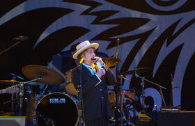 Am 10. Dezember ist es nun soweit: Bob Dylan bekommt die Krone für Lebenswerk, Musik, literarisches Schaffen – den Literaturnobelpreis. Doch der Zeremonie im norwegischen Oslo bleibt er fern, schiebt eine terminliche Kollision vor – und das, obwohl der Preis erstmals an einen Sänger verliehen wird. Ein offizieller Konzertauftritt kann es jedenfalls nicht sein, Dylans Tourkalender ist abgearbeitet für dieses Jahr. Seine Abwesenheit? Ein Rätsel. Statt selbst in Oslo zu singen, lässt er sich vertreten: Patti Smith wird für ihn auf der Bühne stehen und sein Protestlied „A Hard Rain’s A-Gonna Fall“ singen, wie die Schwedische Akademie per Twitter mitteilte. Trotzdem soll der Preisträger eine Rede vorbereitet haben, die beim Nobelbankett vorgetragen wird. Von wem, ist bislang unklar. Es ist Bedingung, dass der Gewinner des Literaturnobelpreises innerhalb von sechs Monaten nach der Verleihung eine Rede vorträgt. Traditionell halten die Preisträger eine solche Nobelrede in der Woche vor der Zeremonie. Nur eines hat Dylan der Schwedischen Akademie bei der Frage nach dem Vorleser deutlich gemacht: „It Ain’t Me Babe“.